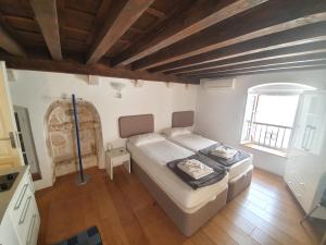 a small bedroom with a bed and a window at Old Town Hvar Apartment in Hvar