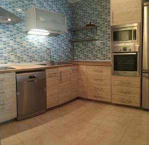 a kitchen with wooden cabinets and stainless steel appliances at FRAMANTIS App No 6 in Costa Calma