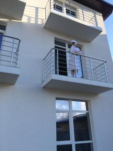 a man standing on a balcony with a dog at FamilyStories in Agoy