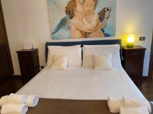 Un dormitorio con una cama blanca con una foto de ángel en la pared en IN FRONT OF COLISEUM 5, en Roma