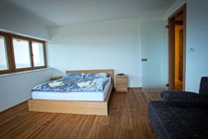 a bedroom with a bed and a couch at Vinařský Penzion in Strachotice