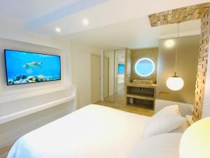 a bedroom with a bed and a television on a wall at Feel@Home Nemausus « Le 21 » in Nîmes