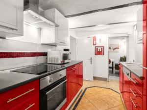 a kitchen with red cabinets and a microwave at Cosy apartment in Grevesmühlen with parking in Grevesmühlen