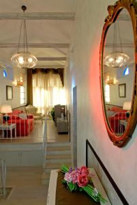 una habitación con espejo y una mesa con flores. en Villa Helvetia, en Grottammare