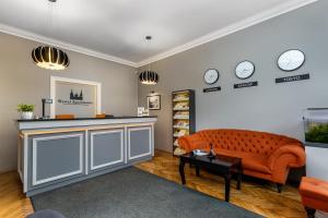 a living room with a couch and clocks on the wall at Wawel Apartments - Jewish District in Krakow