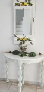 a white table with a mirror and flowers on it at Hotel Anezina in Drios