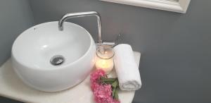 a bathroom sink with a candle and flowers on it at Hotel Anezina in Drios