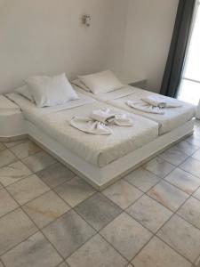 a white bed with two towels on top of it at Hotel Anezina in Drios