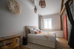 KRAFFT, centre ville, climatisé, baignoire double - La Clé des Sacres في رانس: غرفة نوم صغيرة مع سرير وطاولة