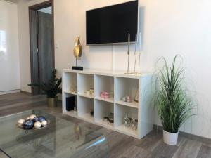 a living room with a tv on a wall at Glamour Apartman in Tapolca