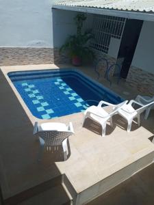 a swimming pool with two lounge chairs and a table at CASA BLANCA GIRARDOT in Girardot
