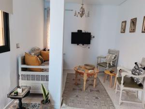 a living room with a table and a tv at BEL APPART A SiDi BOUSAID in Sidi Bou Saïd