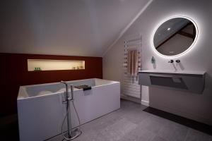 uma casa de banho com uma banheira, um lavatório e um espelho. em KRAFFT, centre ville, climatisé, baignoire double - La Clé des Sacres em Reims