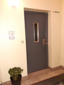 a gray door in a room with a potted plant at Espaço_Zero[Downtown] 01 in Porto