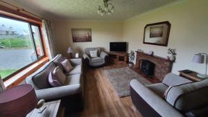 Eoropie的住宿－Kilronan Self Catering - Eoropie, Isle of Lewis，客厅设有两张沙发和一个壁炉