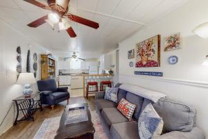 uma sala de estar com um sofá e uma ventoinha de tecto em Grace Cottage em Kingsland