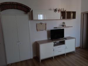 a living room with a tv and a white cabinet at Casa Argentina in Capoliveri