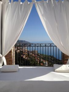 1 dormitorio con cama y vistas al océano en Isoco Guest House, en Taormina