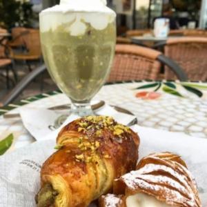 um prato branco com um croissant e uma bebida numa mesa em T'Amo em Lipari