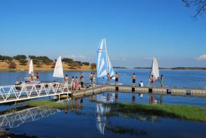 a group of people on a dock with sailboats on the water at Recanto na Planicie in Monsaraz