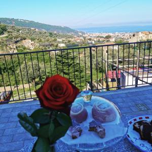 - une table avec une rose et une assiette de biscuits dans l'établissement L'Angolo di Campagna, à Piano di Sorrento