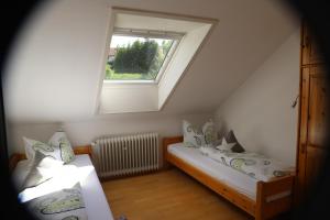 a attic room with two beds and a window at Ferienwohnung Schmidt im Haus Elisabeth in Feldberg