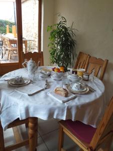 a table with a white table cloth with food on it at LA PETITE MAISON DU SABOT in Langonnet +10 photos