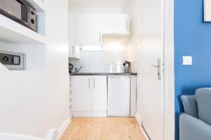 a small kitchen with white cabinets and a sink at Azur Studios Cannes in Cannes