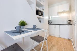 a small kitchen with a table and a chair at Azur Studios Cannes in Cannes
