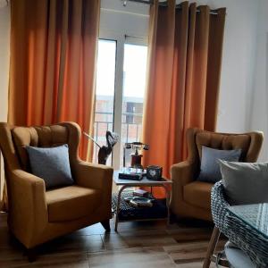 uma sala de estar com duas cadeiras e uma janela em Apartments Maljevic em Bar