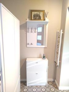 a bathroom with a white dresser and a mirror at Apartament pod Chełmcem in Szczawno-Zdrój