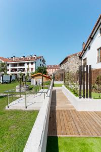 a wooden walkway in a park with buildings at Jardines Villaverde in Villaverde de Pontones