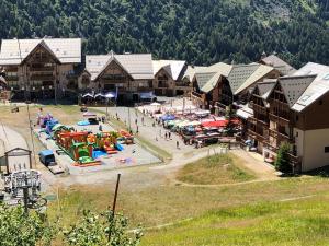 Una vista aérea de un complejo turístico con un parque acuático. en Pied de pistes, résidence 3 étoiles tout confort dont terrasse et piscine, en Valmeinier