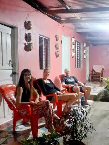 un grupo de personas sentadas en sillas en una casa en Guest House Nena en Moyogalpa