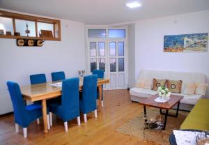 - une salle à manger et un salon avec une table et des chaises bleues dans l'établissement Garden's apartman - Kosjerić, à Kosjeric