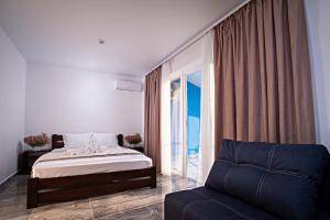 una camera da letto con un letto, un divano e una finestra di Agata Breeze a Kobleve