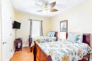 a bedroom with two beds and a ceiling fan at Tropic Isl 501 in Gulf Shores +23 photos