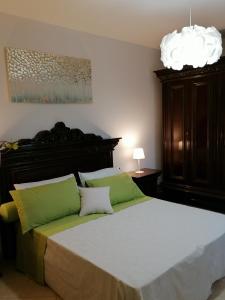 a bedroom with a large bed with green pillows at Suite Maria in Agliana