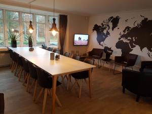 a conference room with a table and a world map on the wall at Sdr. Omme Bed & Breakfast in Sønder Omme