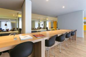 a conference room with a long wooden table and chairs at Vossa Bossa VN Turiassu in Sao Paulo