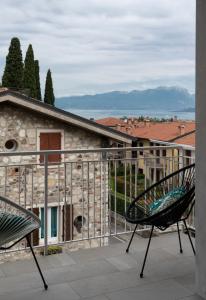 a balcony with two chairs and a building at Casa blu in Lazise