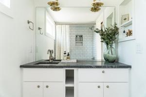 a white bathroom with a sink and a mirror at Ironwood Grove, Tiny House Hotel in Nashville