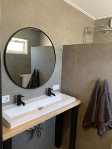 a bathroom with a sink and a mirror at DOCK10TEXEL in De Cocksdorp