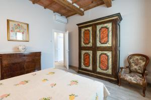um quarto com uma cama, uma cadeira e uma cómoda em EM Apartment em Siena