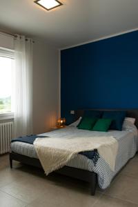 a bedroom with a large bed with a blue wall at Casa blu in Lazise