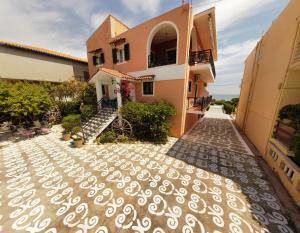 a villa with a pathway in front of a house at Alisaxni Studios in Argasi