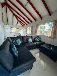 a living room with a blue couch and windows at Ocean Breeze Villa in Rarotonga