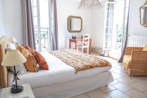 a bedroom with a bed and a table and a mirror at Logis hôtel et restaurant La Bastide Cabezac in Bize-Minervois