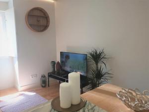 ein Wohnzimmer mit einem TV und einem Tisch mit Kerzen in der Unterkunft Principe Real Central Home in Lissabon
