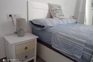 Habitación pequeña con cama y mesita de noche en Precioso apartamento con terraza en Teguise, en Teguise